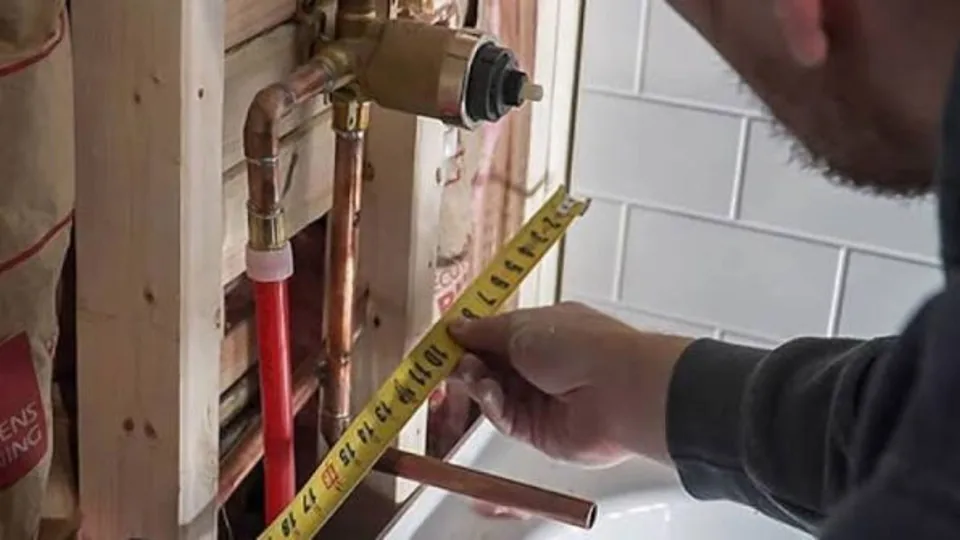 Plumber measuring copper supply stubs in a bathroom rough-in, Bathroom Plumbing in Downey, CA