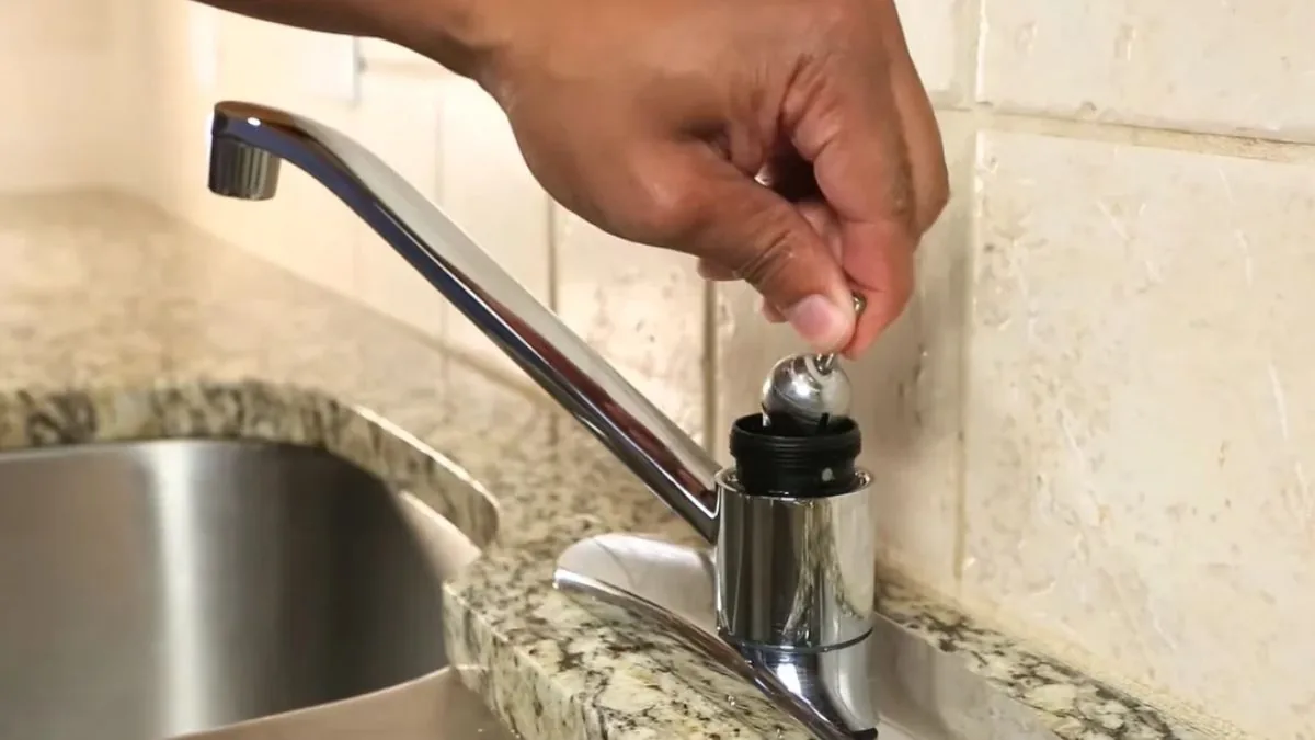 Hand adjusting the stem of a kitchen faucet, Faucet and Sink Repair in Downey, CA