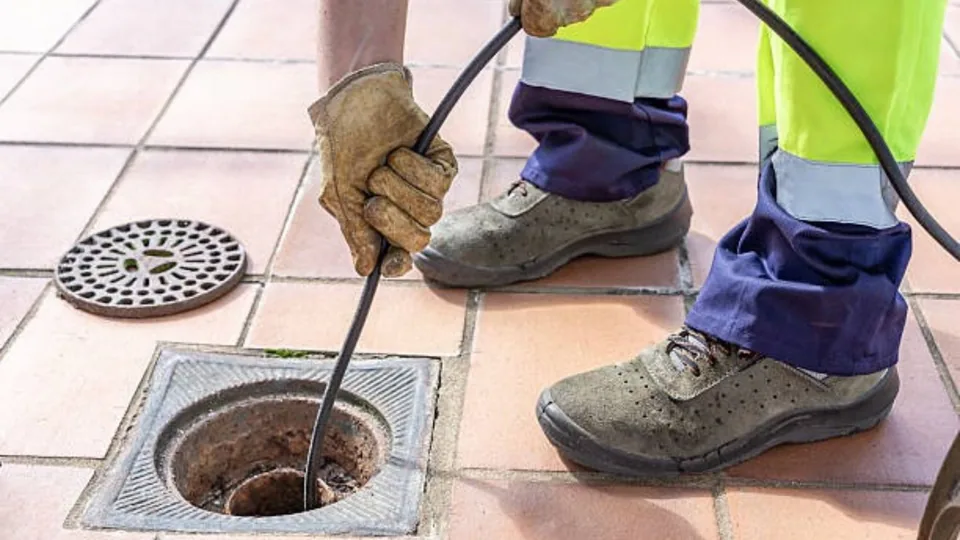 Technician feeding a jetting hose into a floor drain, Hydro Jetting in Downey, CA