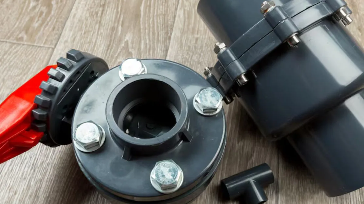 Grey PVC flanged valve and tee fittings laid on a floor